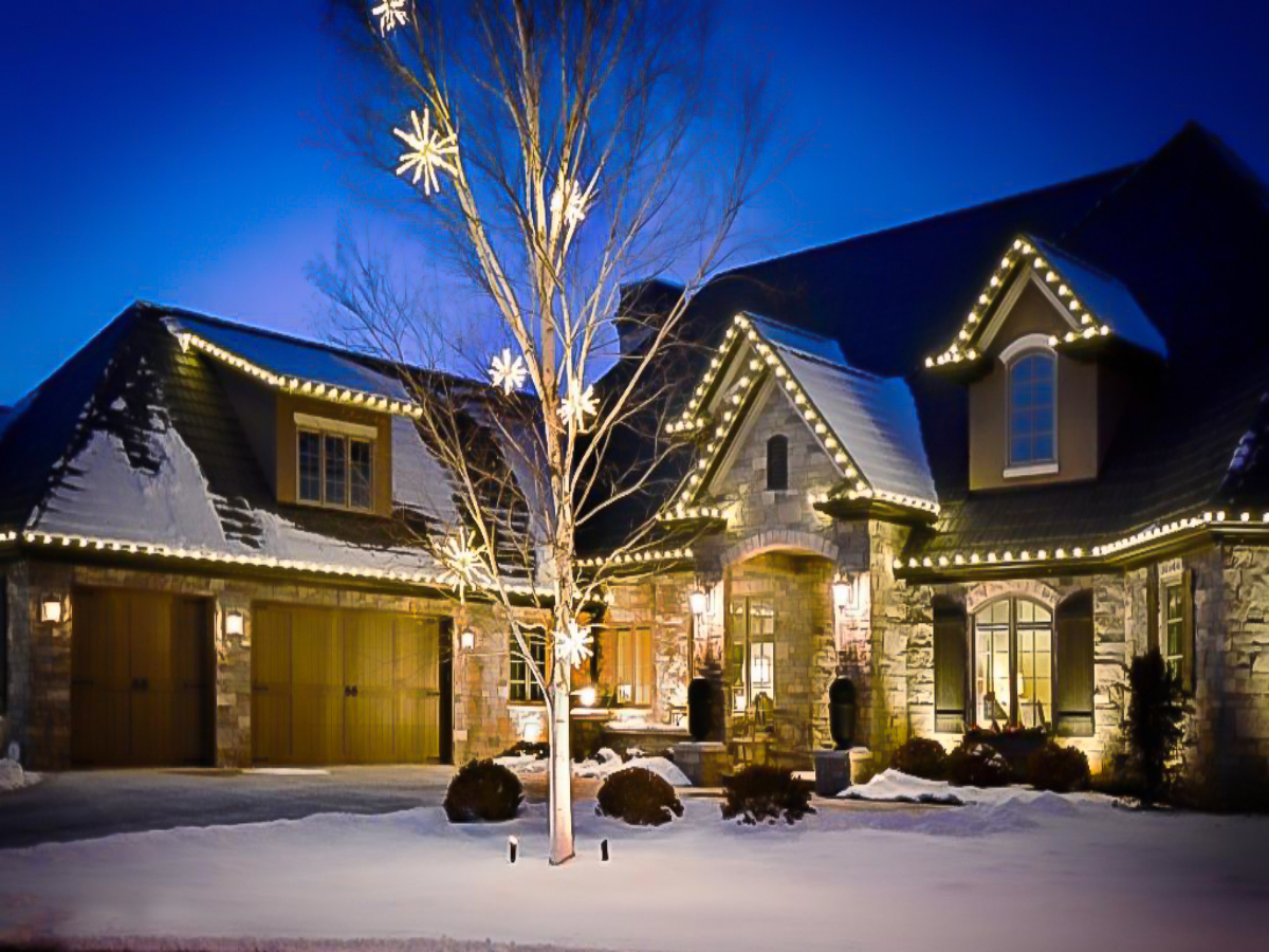 Roofline Christmas lights on two-story brick home in Massachusetts